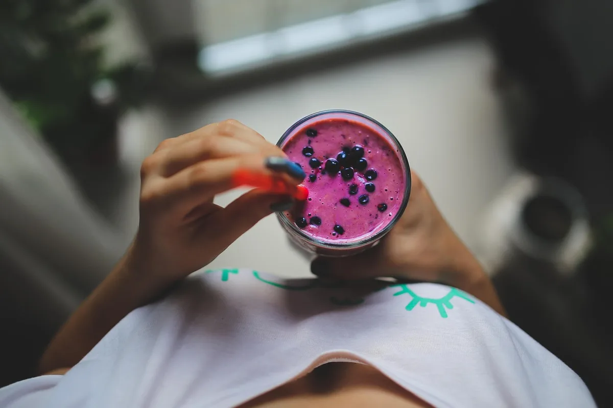 A light bowl of plain yogurt with fresh berries and a small jar of fermented vegetables on the table