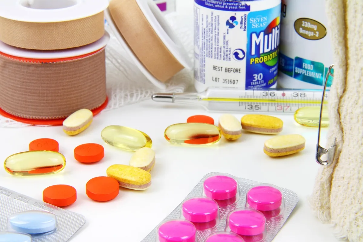 Close-up of anonymous hands holding a small pill bottle and a notepad about dosages, no labels visible