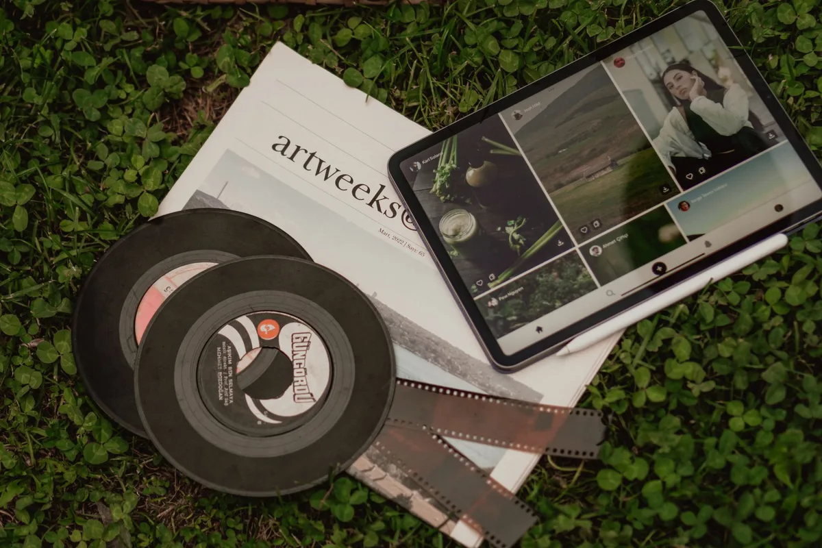 An open tablet on a kitchen table showing a generic digital magazine layout, a coffee cup to the side and reading glasses nearby